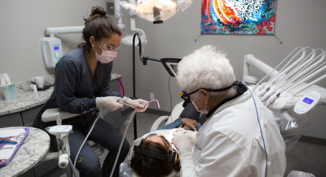 Dentist and assistant working on patient in dental chair